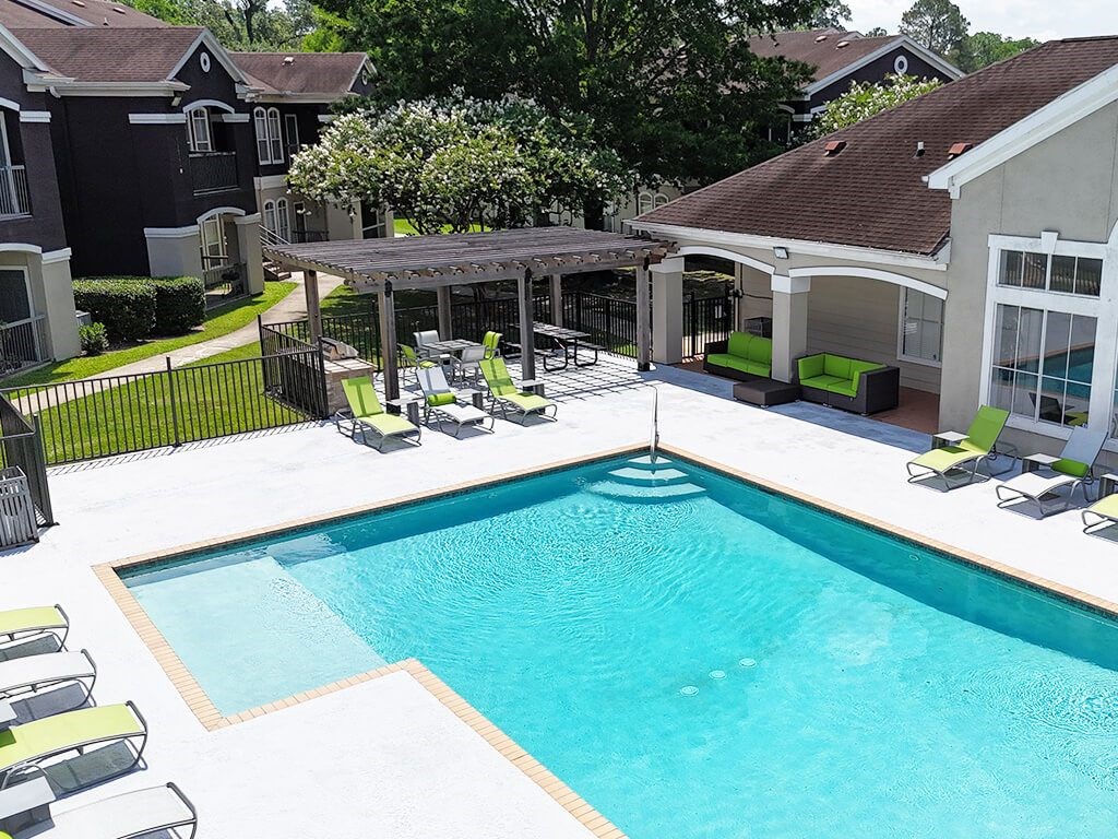 A swimming pool with a deck and lounge chairs.