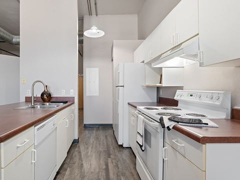 a kitchen with white appliances and wooden counter tops and white cabinets