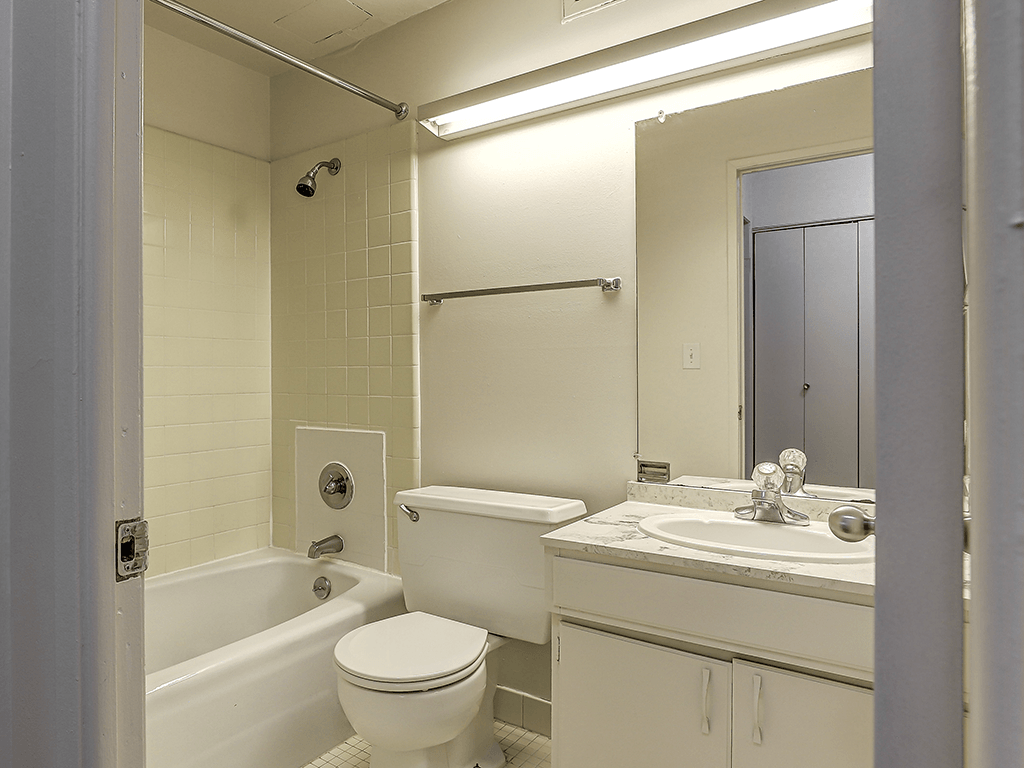 A white bathroom with a toilet, sink, and bathtub.