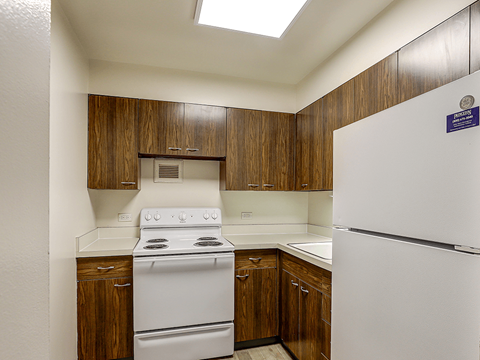 A kitchen with a white stove and refrigerator.