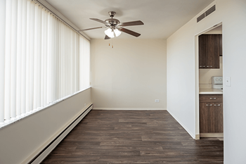 A room with a ceiling fan and wooden flooring.