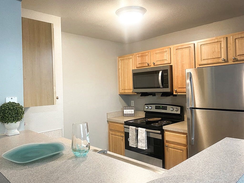 A kitchen with a stove, microwave, and refrigerator.