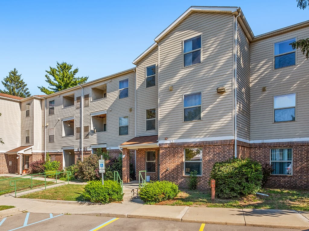 Apartment building with a parking lot in front.