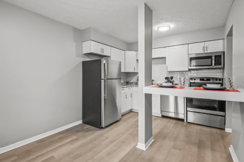 A kitchen with a refrigerator, oven, and microwave.
