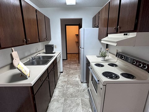 a kitchen with brown cabinets and white appliances