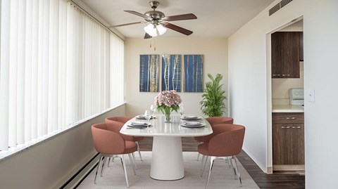 A dining room with a white table and chairs.