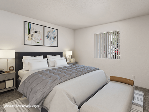 A bedroom with a large bed and two framed artworks on the wall.