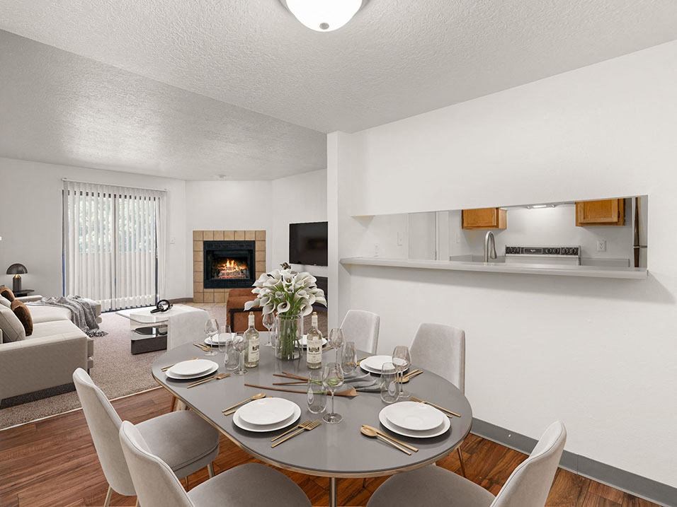 a dining area with a table and chairs and a fireplace in the background