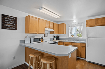 A kitchen with wooden cabinets and white appliances.