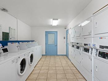 a laundry room with washers and dryers and a blue door