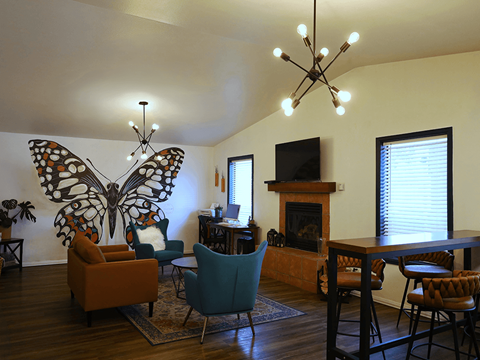 A living room with a fireplace and a butterfly mural on the wall.