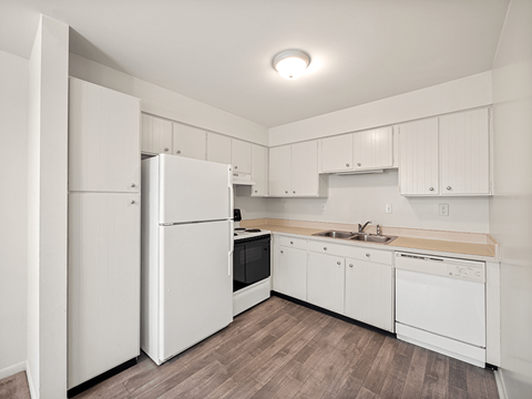 A kitchen with white appliances and cabinets.