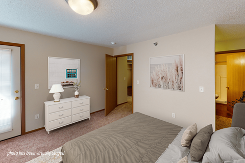 A bedroom with a bed, dresser, and two pictures on the wall.