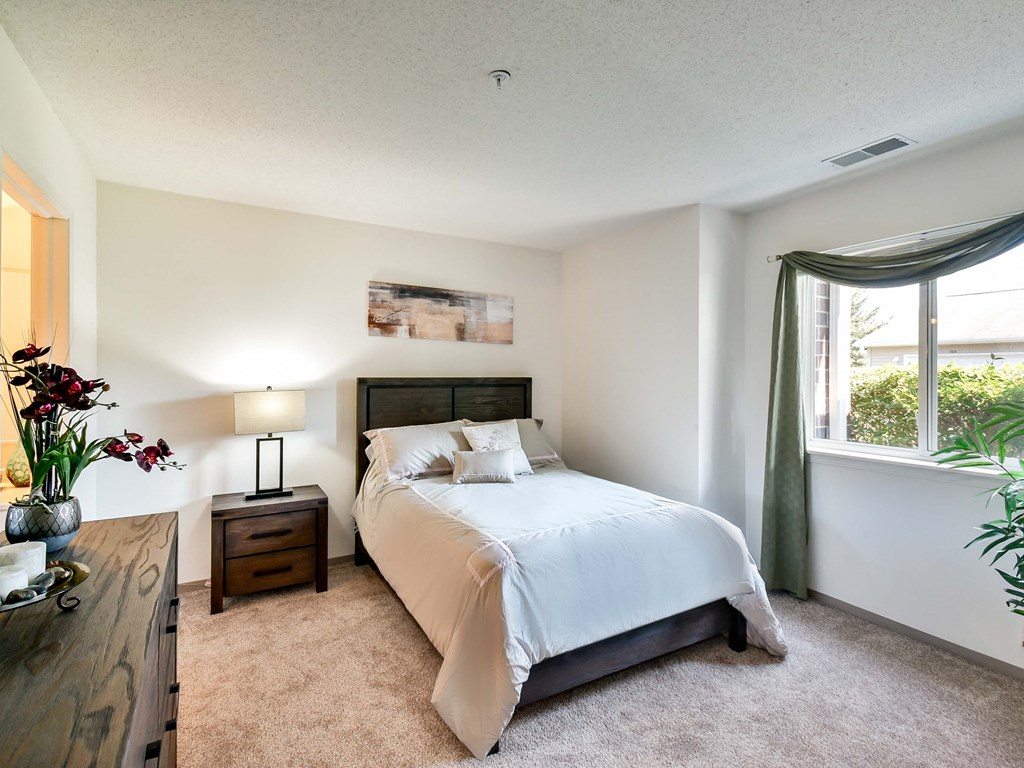 apartment bedroom with a bed and a window
