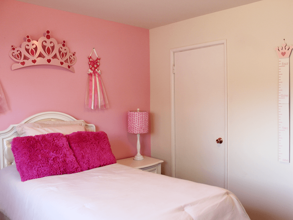 a pink bedroom with a white bed