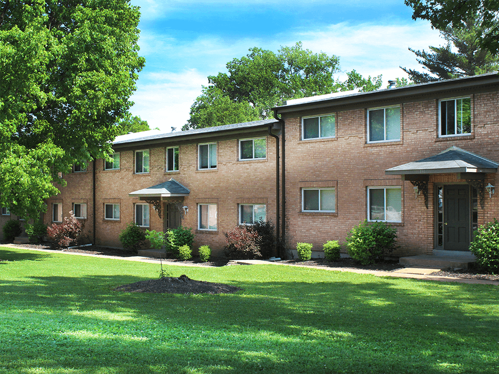 large brick apartment building with a lawn