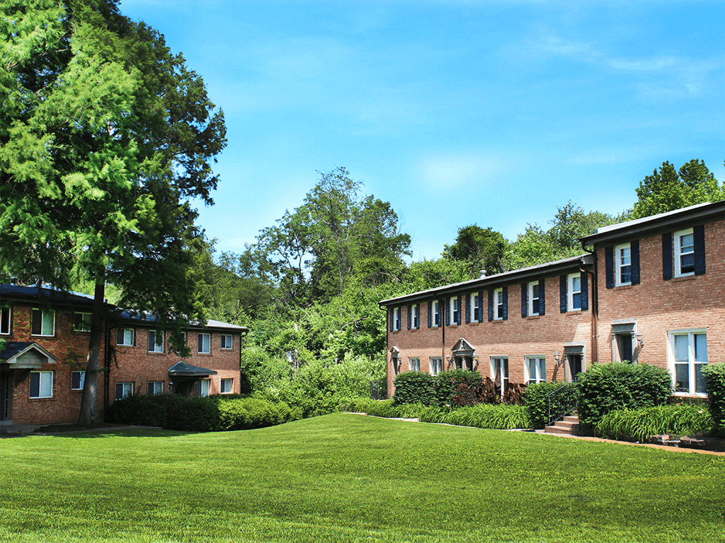 green lawn in front of a brick apartment building
