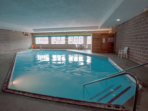 A small indoor swimming pool with a metal ladder.