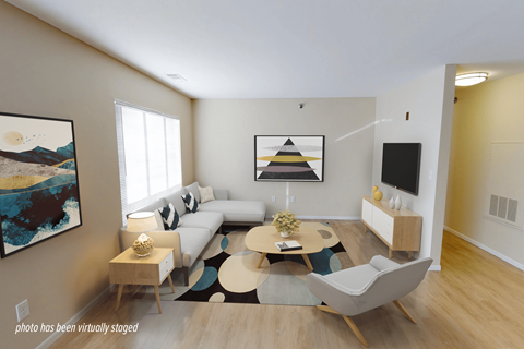 A living room with a white couch, a coffee table, and a painting on the wall.