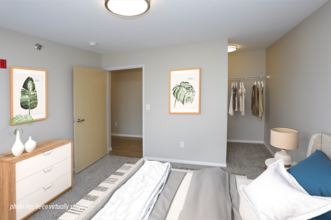 A bedroom with a bed, dresser, and closet.