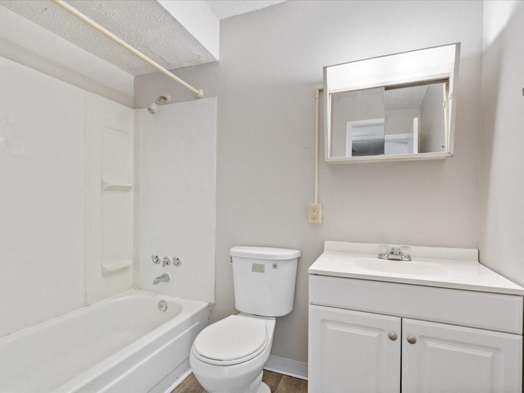 apartment bathroom with a toilet and a bath tub