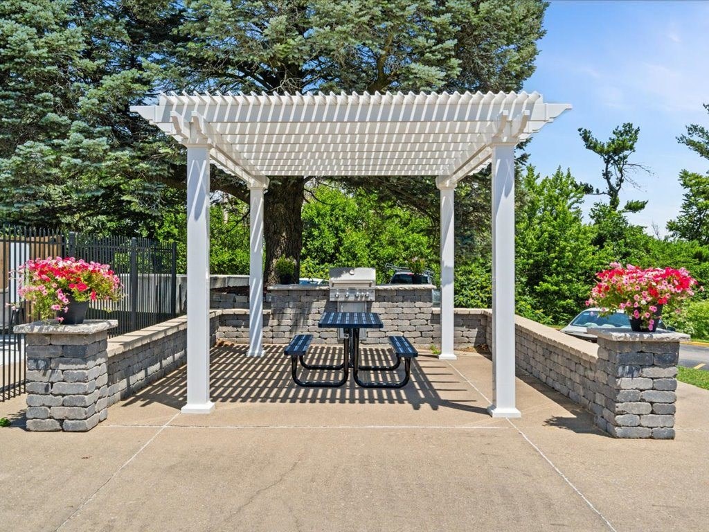 patio area with a picnic table and a pergola
