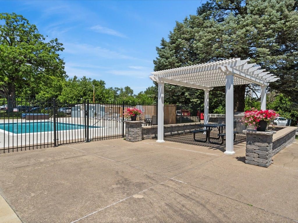 a swimming pool with a picnic table under a white canopy