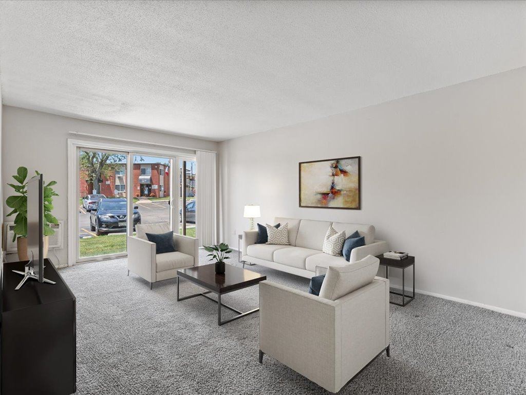 the living room of an apartment with a couch and chairs