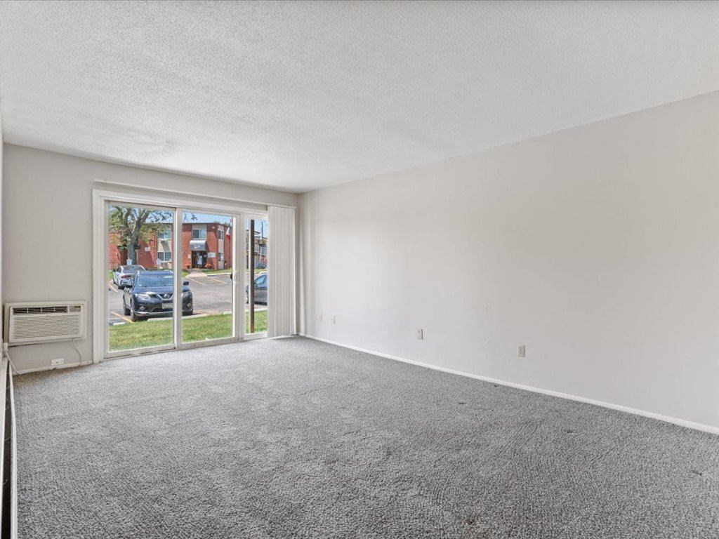 the living room of an apartment with a large window