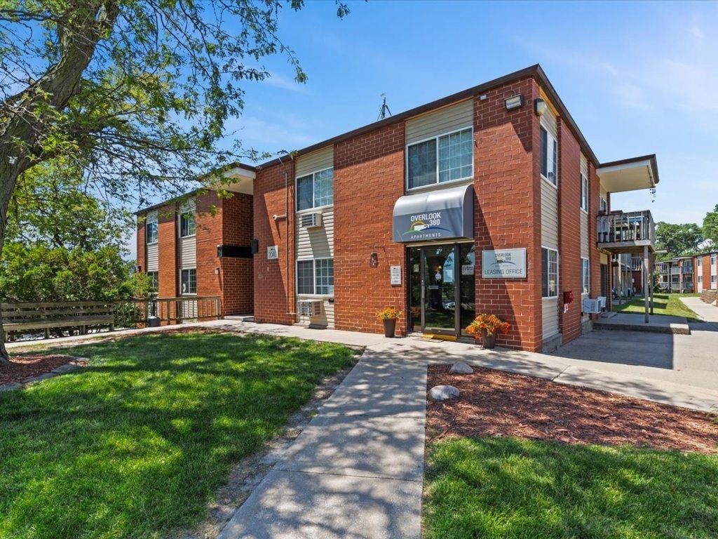brick apartment building with a sidewalk