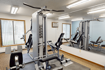 A gym with a variety of equipment including a leg press machine.