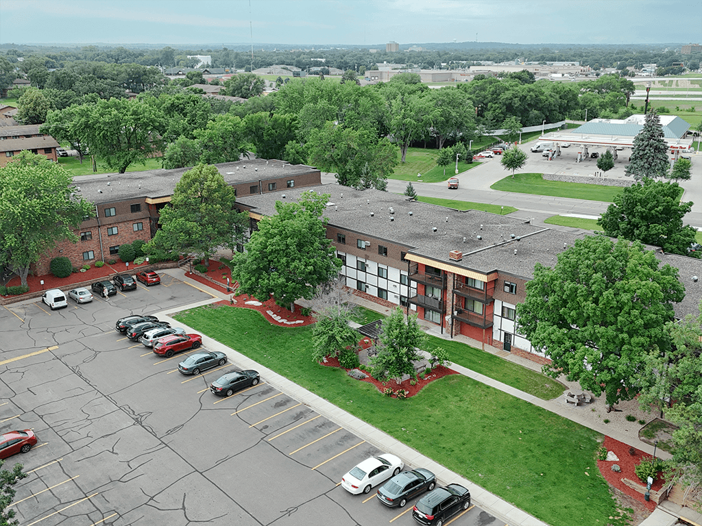 A parking lot with cars and a building in the background.