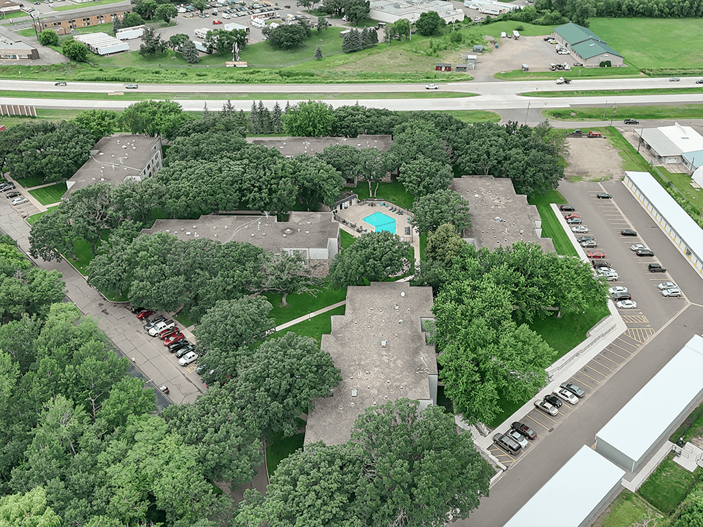 A bird's eye view of a parking lot surrounded by trees.