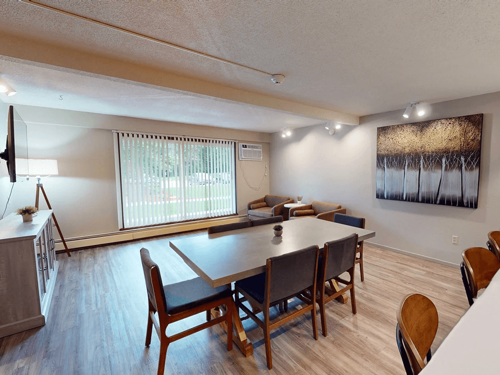 A dining room with a long table and chairs.