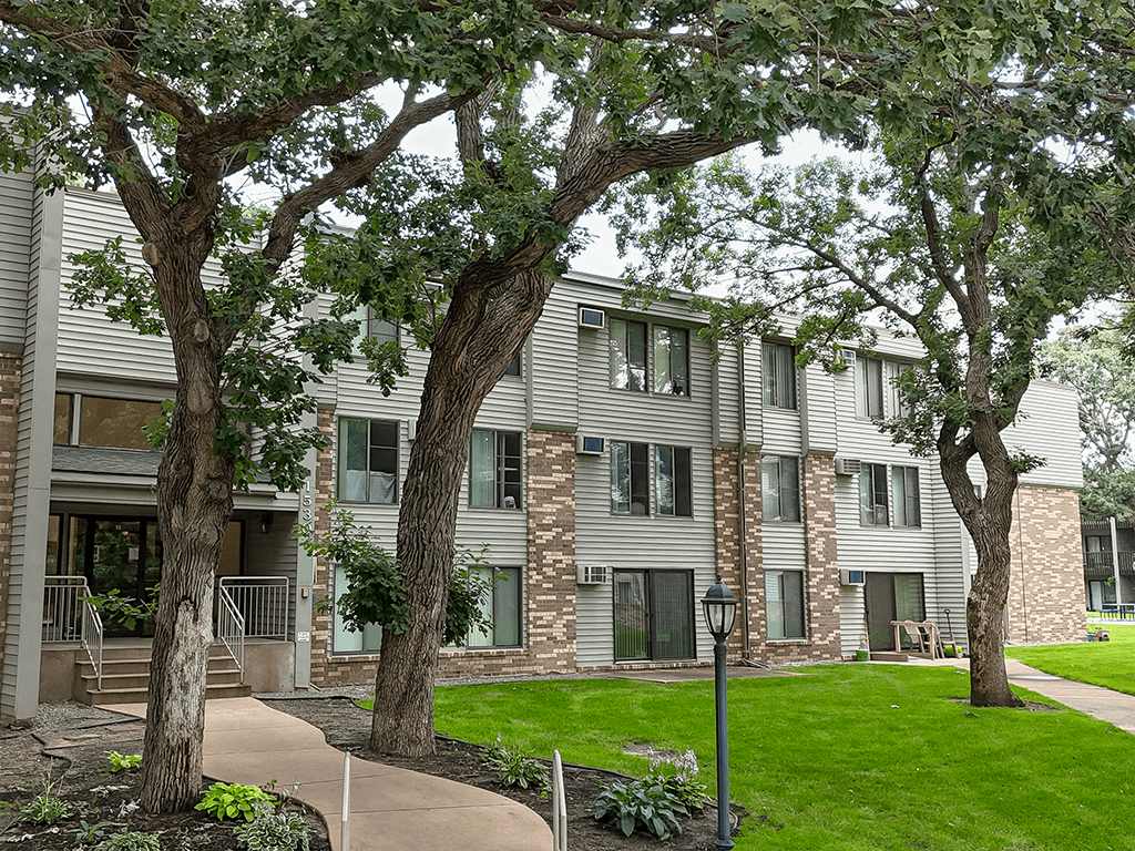 A building with a green lawn in front.