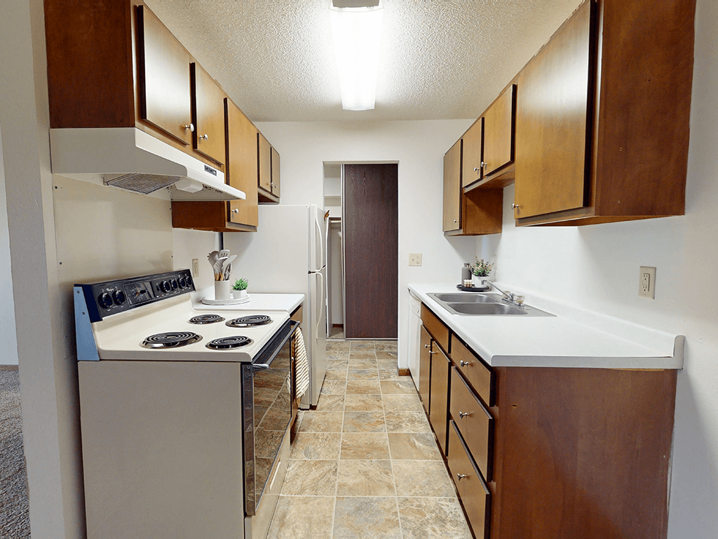 A kitchen with a stove top oven and a sink.