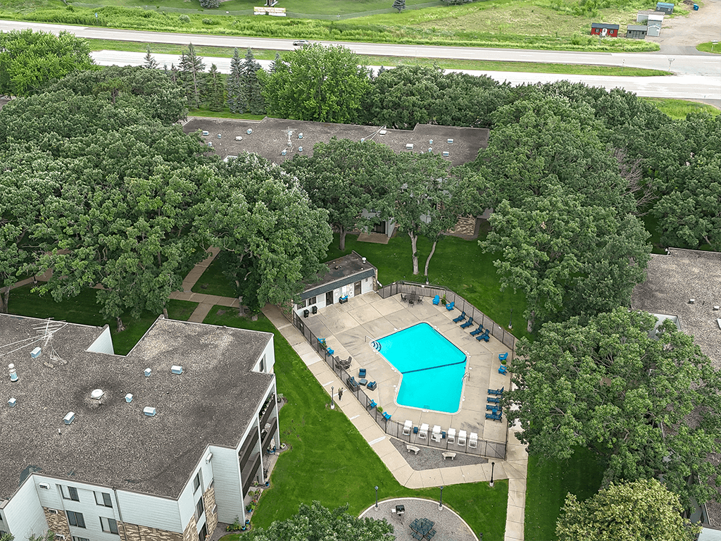 A swimming pool surrounded by trees and a building.