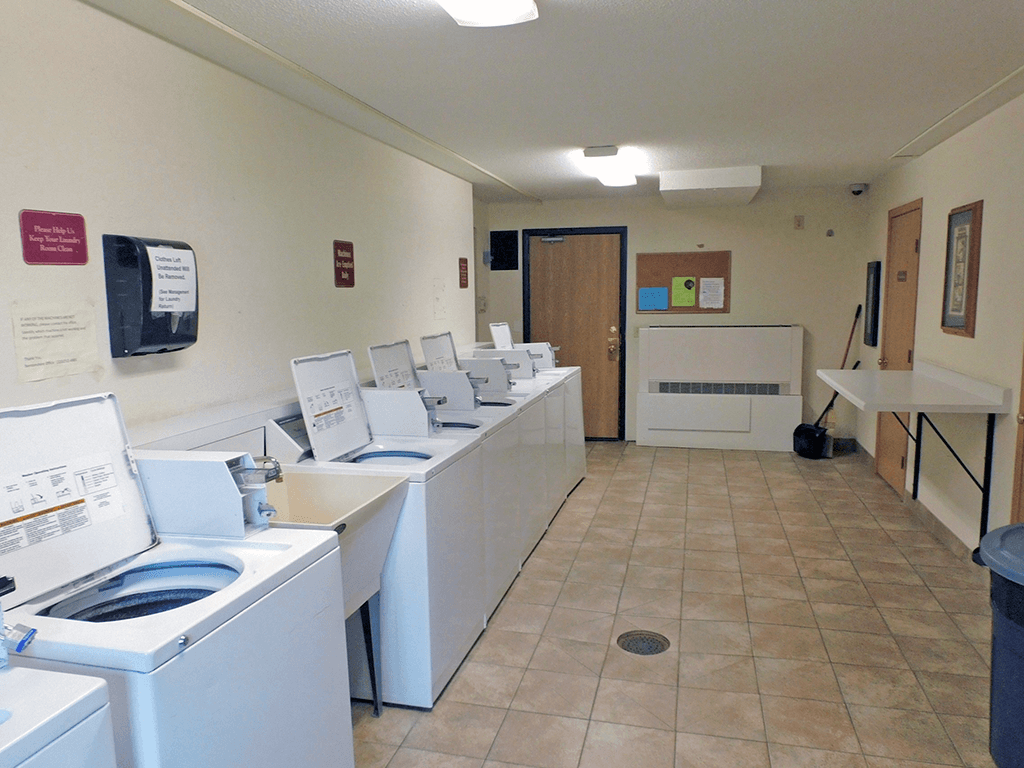 a washer and dryer room with a row of washing machines