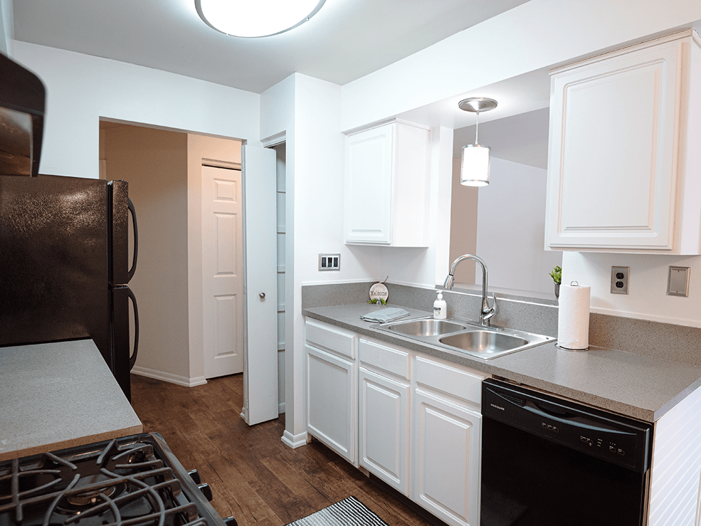 a kitchen with white cabinets and a sink and a refrigerator
