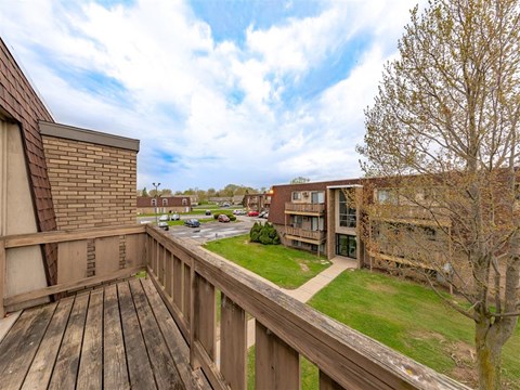 A balcony with a wooden floor and a wooden fence.