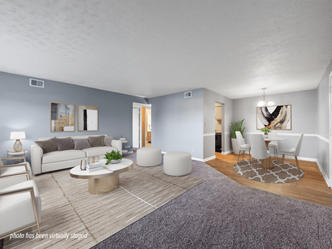A living room with a grey couch, a white coffee table, and a grey rug.