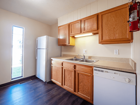 A kitchen with wooden cabinets and a white dishwasher.