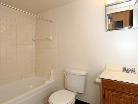 A white toilet sits next to a white sink in a bathroom.