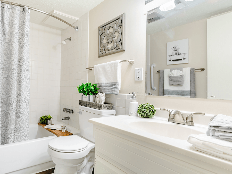 a white bathroom with a white toilet and tub and a white sink