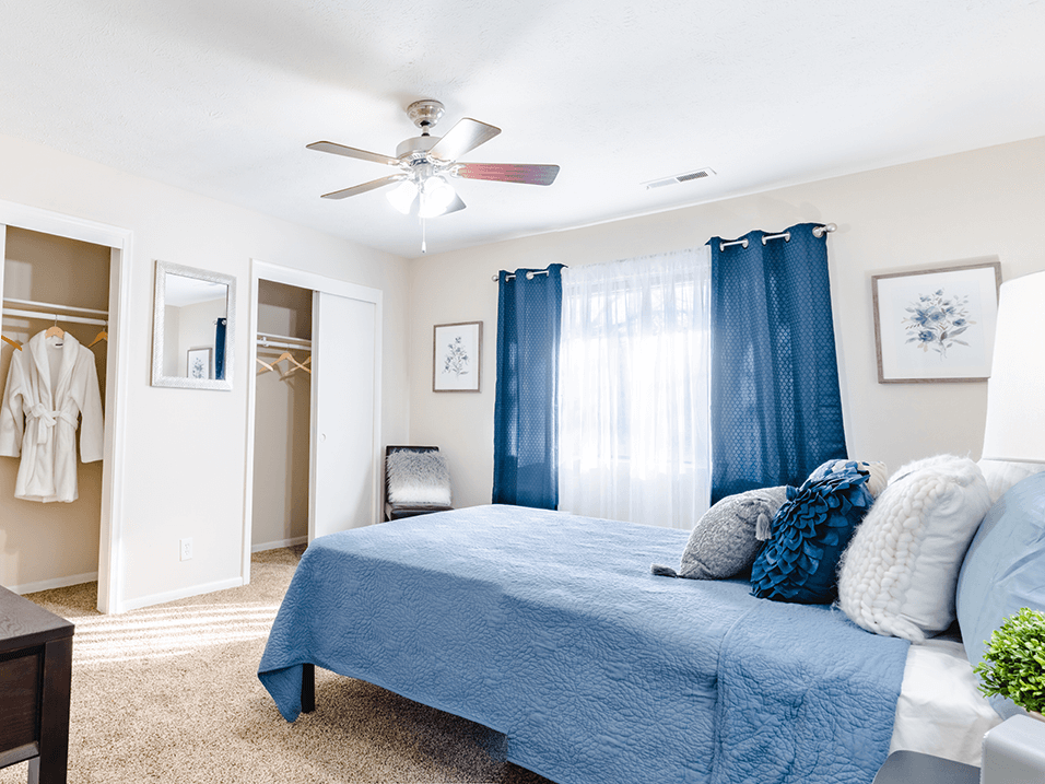 a bedroom with a bed and a ceiling fan