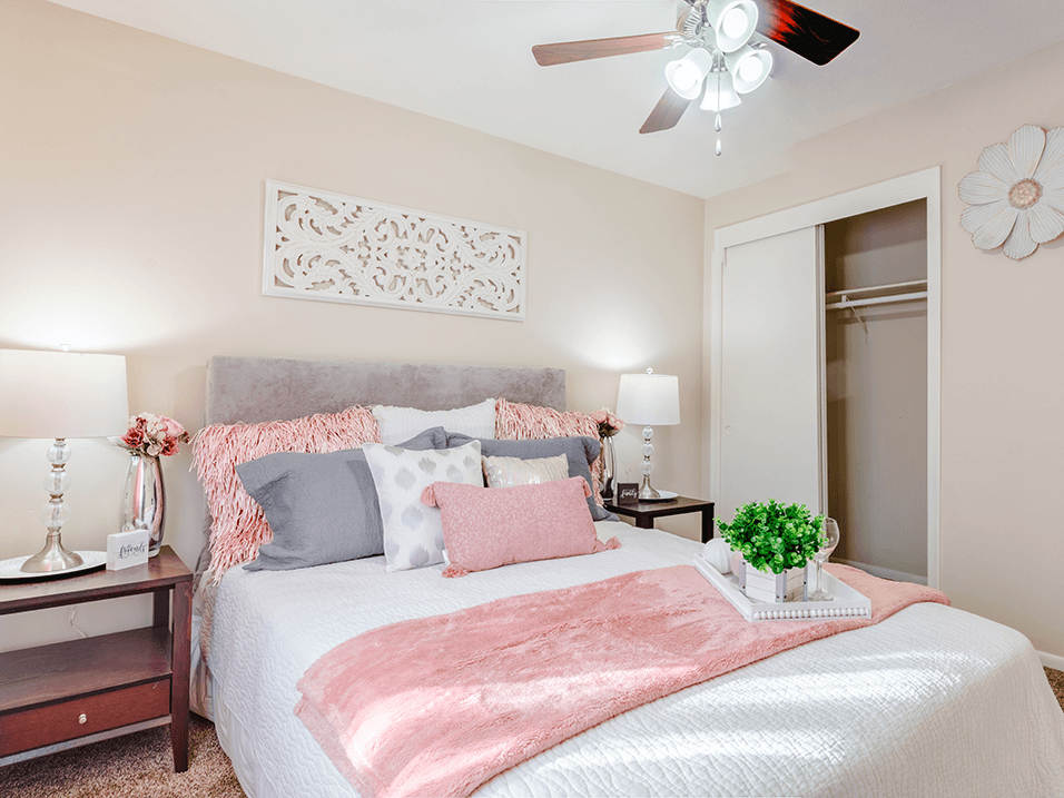 a bedroom with a large bed and a ceiling fan
