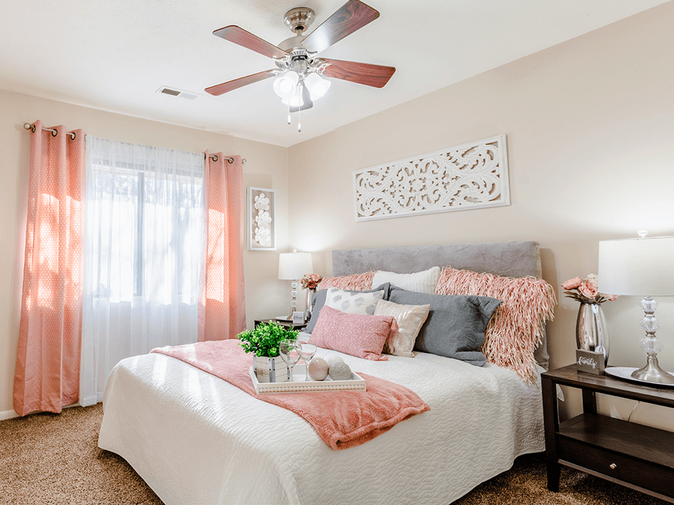 a bedroom with a large bed and a ceiling fan