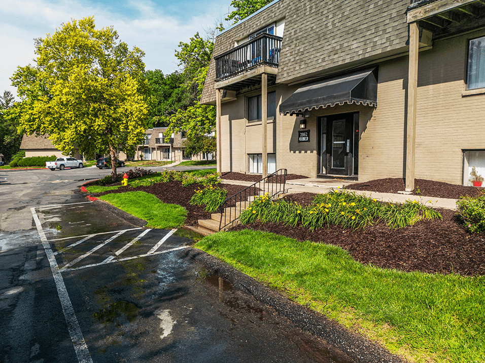 a rain soaked parking lot in front of an apartment building
