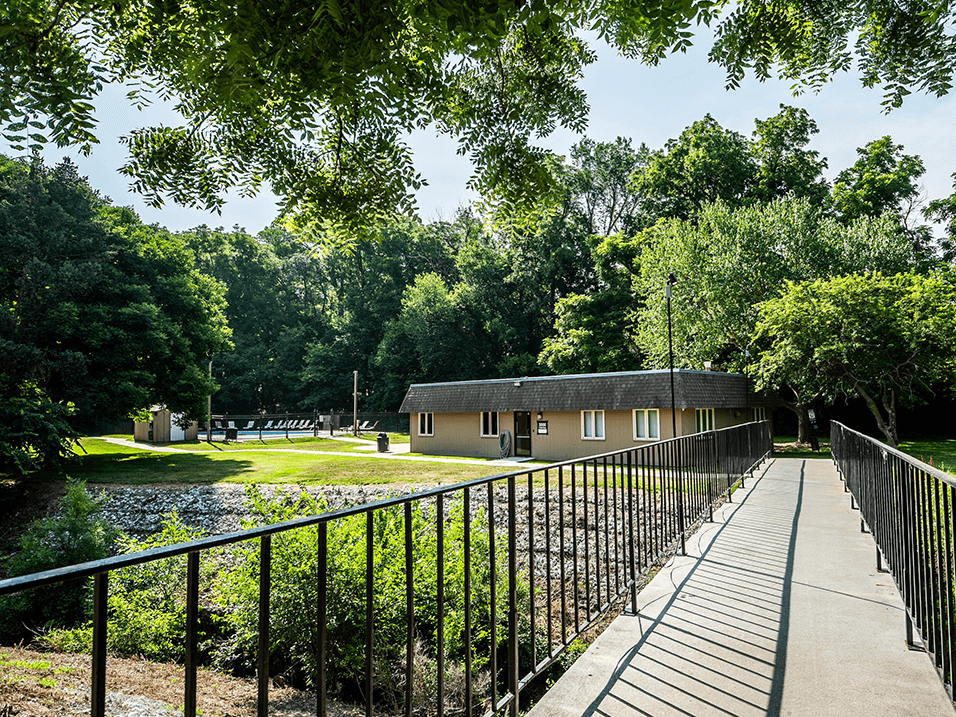 a bridge crosses a pond in front of a building