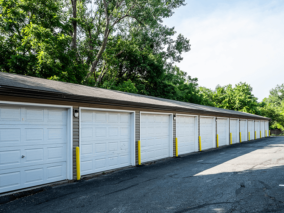 a row of garages with white doors and a gray roof